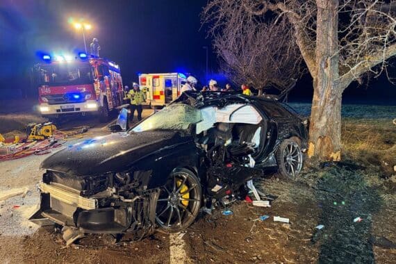 Zertrümmerter Pkw nach Aufprall auf Baum, Rettungskräfte im Einsatz, tragischer Verkehrsunfall dokumentiert.