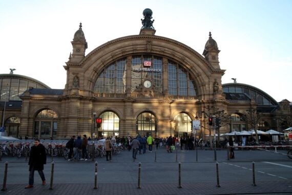 Frankfurter Hauptbahnhof mit deutlich sichtbarem „Alkoholverbot“-Schild und Reisenden im Hintergrund.