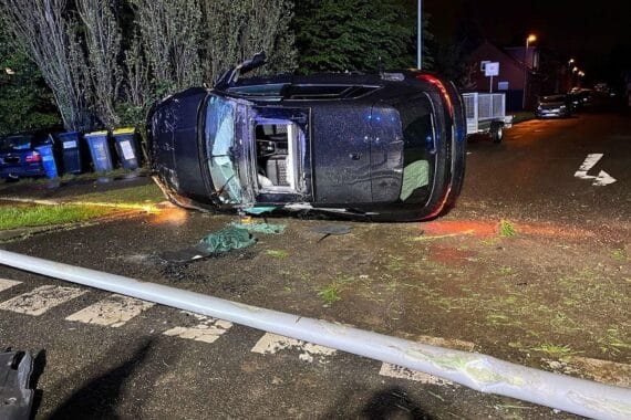Audi RS3 nach Unfall überschlagen, Ampelmast und Laterne beschädigt, Polizei ermittelt.