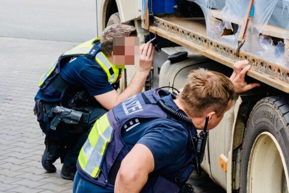 Polizei und Zoll kontrollieren Lastwagen auf Parkplatz, zahlreiche Verstöße im gewerblichen Verkehr festgestellt.