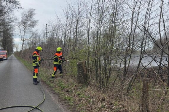 Feuerwehreinsatz bei Böschungsbrand an Bahnstrecke, Hubschrauber und zahlreiche Einsatzkräfte aktiv.