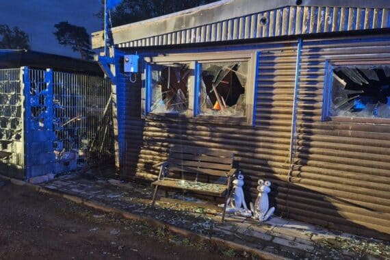 Campingplatz mit Feuer; Feuerwehr im Einsatz, Rauch und Löscharbeiten sichtbar.