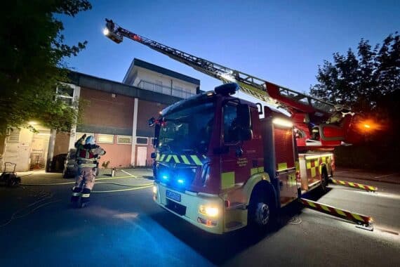 Feuerwehr bekämpft Brand in Ladenlokal, starke Verrauchung, Einsatzkräfte im Alarmmodus.