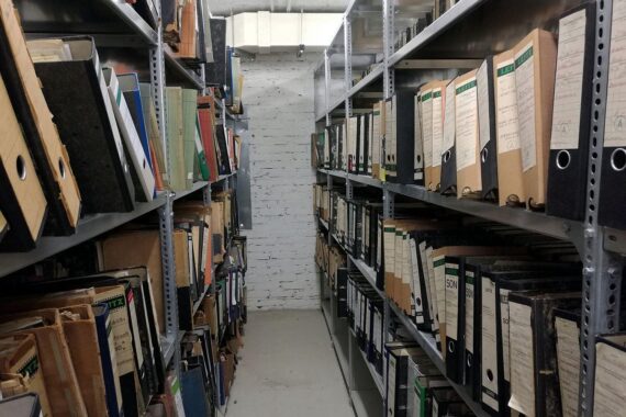 Auf dem Bild sind Aktenordner zu sehen, symbolisch für Bürokratie in der Verwaltung.