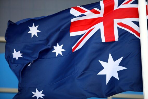 Australische Flagge vor symbolischem Hintergrund für Rohstoffversorgung und Energiewende.