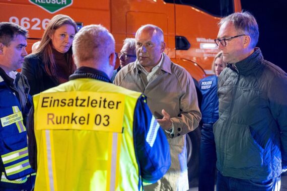 Traurige Szene: Menschen trauern um Arbeitsunfallopfer, Rettungskräfte leisten professionelle Hilfe.
