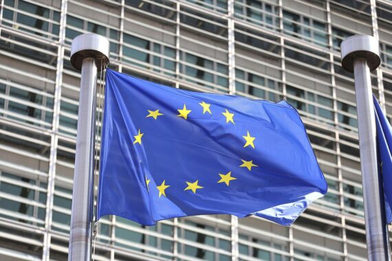 EU-Fahnen im Vordergrund, Symbol für Zusammenarbeit und Herausforderungen in der Verteidigungspolitik.