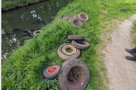 Illegal entsorgte Altreifen am Flussufer: Umweltverschmutzung und Gefahr für Wasserqualität.
