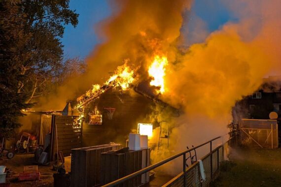 Brennende Gartenlaube, Feuerwehr im Einsatz, Explosion einer Gasflasche, eindrucksvolles Bild von Feuerwehrarbeiten.