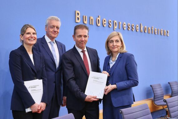Bild zeigt Gesundheitsministerin Warkens und Finanzkommission bei Diskussion über Sparprogramm und Beitragsanhebung.