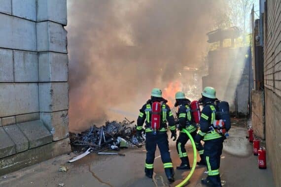 Großeinsatz der Feuerwehr zur Brandbekämpfung in Recyclingbetrieb, metallisches Material brennt.