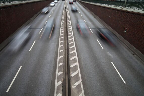 Ein Straßenverkehrsbild mit deutlich sichtbaren Geschwindigkeitsbegrenzungen und Verkehrsschildern.