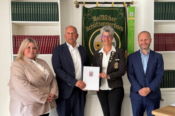 Vier Personen überreichen Förderbescheid für Präventionsprojekt gegen Extremismus in Hessen.