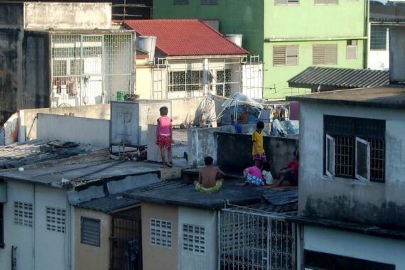 Kinder spielen in einem Slum, während Schuldenkrisen und Armut die Zukunft gefährden.