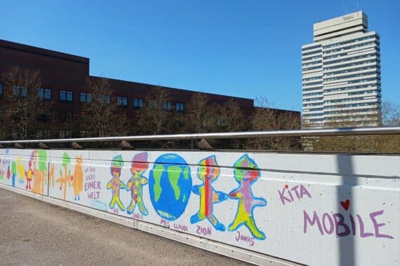Bunte Graffiti von Kindern verschönern Fußgängerbrücke über Ludwigstraße in Kaiserslautern.