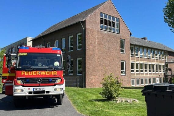 Feuerwehrkräfte bekämpfen Brand in Schule, Schüler evakuiert, leichte Verletzungen durch Rauchgas.