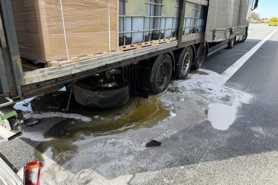 Zwei Lkw-Unfall auf Autobahn mit ausgelaufener Flüssigkeit, Feuerwehr im Einsatz, gesperrte Fahrbahn.
