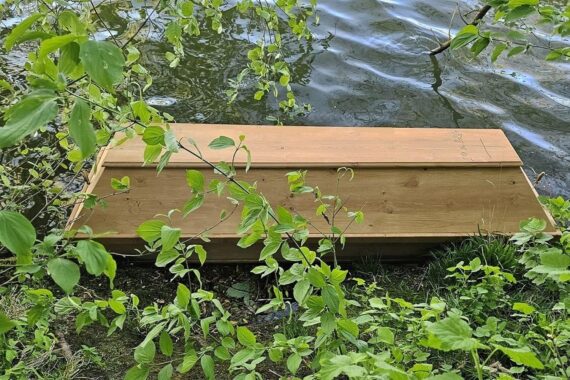 Ein leerer Sarg im Fluss, Polizei und Feuerwehr bei Bergung am Mainufer.
