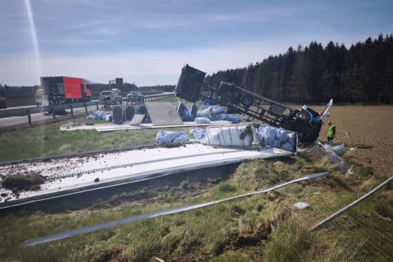 Schwerer Lkw-Unfall auf Autobahn: Umgekippt, Fahrer verletzt, Fahrbahn gesperrt, Stau entsteht.