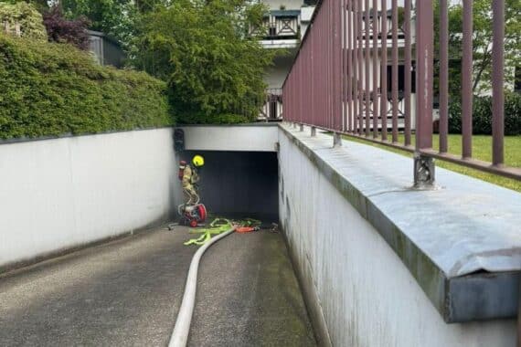Ein Oldtimer in einer Tiefgarage, Rauchentwicklung, Feuerwehr im Einsatz zur Rettung.