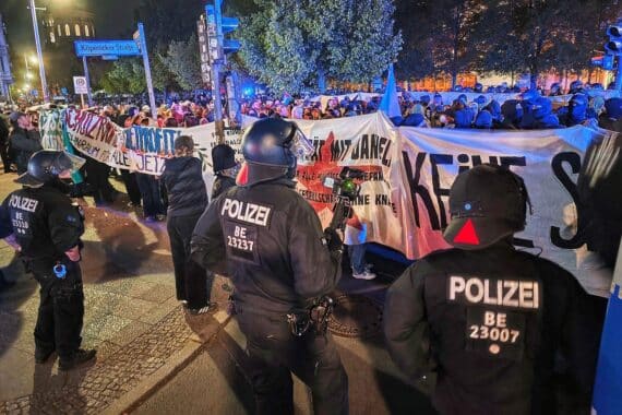 Linke Demonstranten skandieren, Pyrotechnik wird gezündet, Polizeiversammlungen in Berlin nachts.