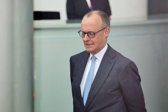 Friedrich Merz bei einer Veranstaltung, umgeben von kritischen ostdeutschen Politikern und Renten-Diskussion.