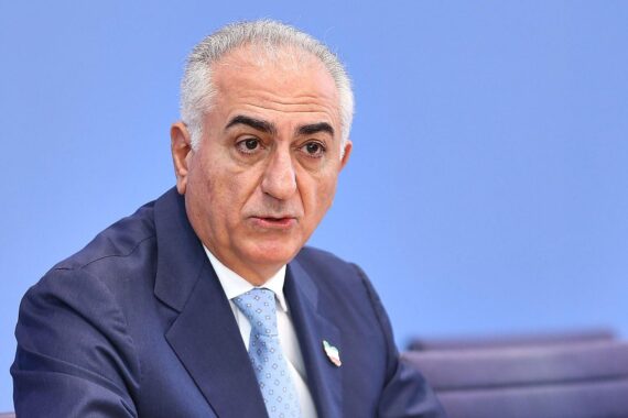 Reza Pahlavi bei Pressekonferenz in Berlin, während er von einem Mann mit Tomate beworfen wird.