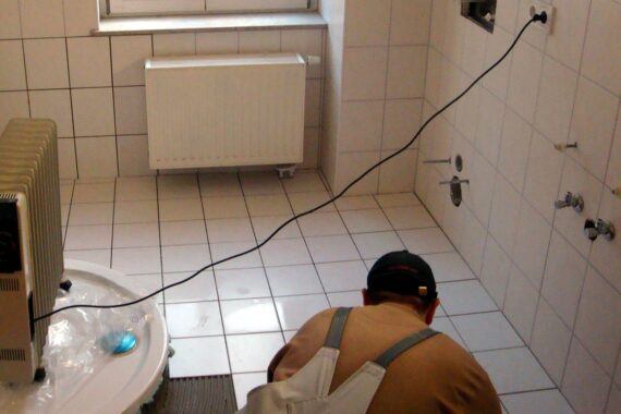 Fliesenleger bei der Arbeit, symbolisiert Handwerksleistungen und mögliche Steuererleichterungen.