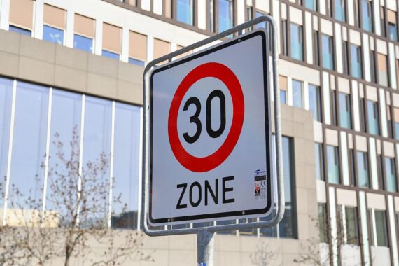 Tempo-30-Schild vor einem Fußgängerüberweg, symbolisiert Sicherheit für Fußgänger im Stadtverkehr.