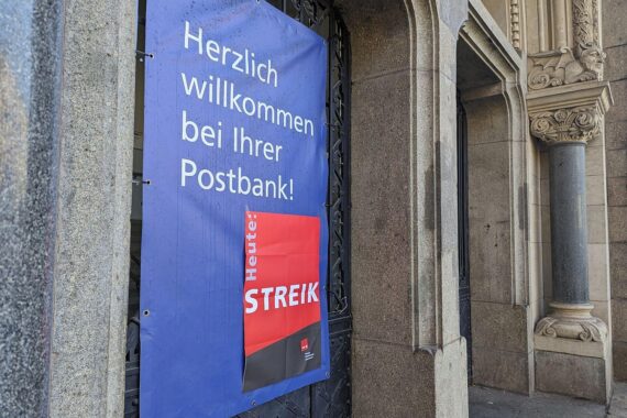 Warnstreik-Hinweis an einer Postbank-Filiale während Tarifverhandlungen für Mitarbeitergehälter.