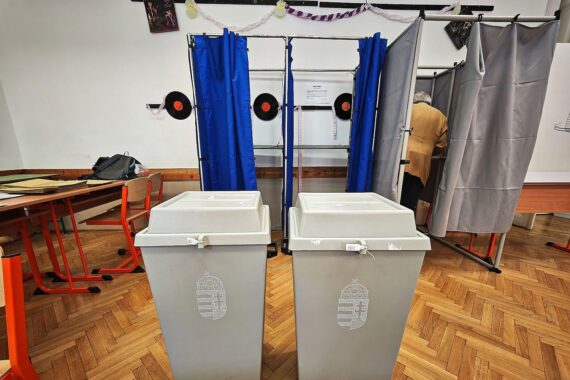 Wahllokal mit Wählern, Wahlurnen und Plakaten: Spannung und mögliche Unregelmäßigkeiten bei ungarischer Parlamentswahl.
