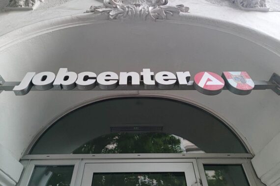 Jobcenter-Schild mit älteren Menschen, symbolisiert steigende Grundsicherungsbezieher, besonders im Alter.