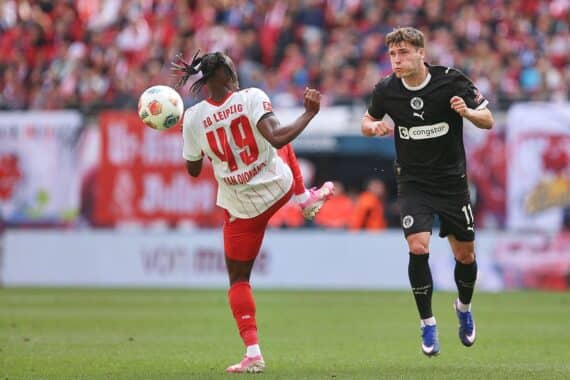 RB Leipzig feiert Sieg gegen St. Pauli, sichert Champions-League-Platz. Dramatische Spielszene abgebildet.