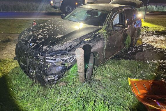 Rettungshubschrauber über Unfallstelle, beschädigtes Auto und Absperrung durch Polizei. Unfallort in Lüdinghausen.