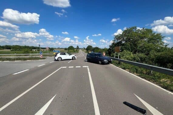 Zwei beschädigte Autos an einer Unfallstelle, Polizei und Feuerwehr sichern den Bereich.