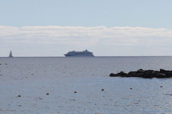 AIDAsol-Kreuzfahrtschiff vor beeindruckender Kulisse, symbolisiert Wachstum und Beliebtheit der Kreuzfahrtbranche.