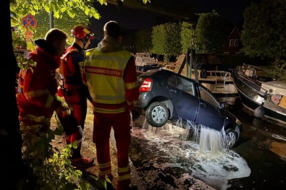 Ein Kran hebt ein versunkenes Auto aus dem Hafenbecken in Aurich.