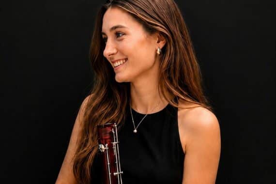 Junge Fagottistin Chiara Martens stolz vor ihrer Musikschule in Bamberg, mit Instrument.