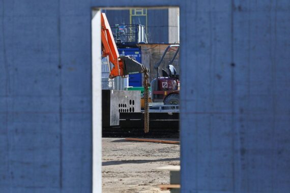 Baustelle mit Arbeitern, Maschinen und unvollendeten Projekten, symbolisiert Infrastrukturprobleme in Deutschland.