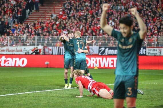 Union Berlin und Werder Bremen spielen im Stadion, umgeben von leidenschaftlichen Fans und Vereinsfarben.