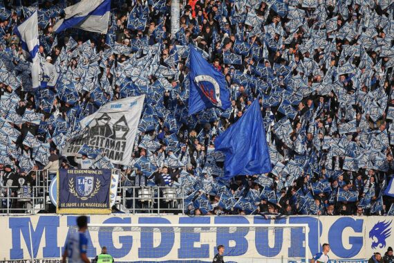 Fußballfans unterwegs zur AVNET-Arena, begleitet von Polizei für Sicherheit und Ordnung.