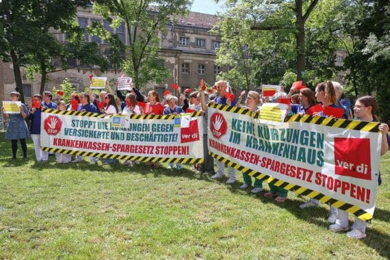 Proteste von Klinikmitarbeitern gegen Sparpläne der Gesundheitsministerin in Berlin, Rote Karten gezeigt.