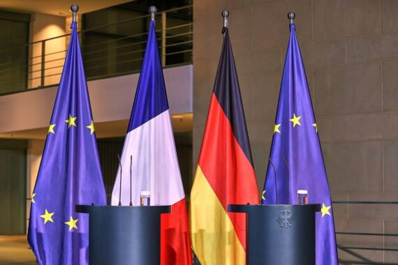 Fahnen von Deutschland, Frankreich und der EU symbolisieren die Zusammenarbeit in nuklearer Abschreckung.