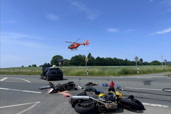 Rettungshubschrauber am Unfallort: Zwei Motorräder und ein Pkw nach schwerem Verkehrsunfall.