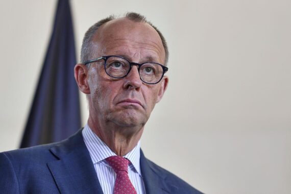 Friedrich Merz im Bundestag, umgeben von politischen Symbolen und den Schlagworten Reform und Wirtschaftswende.