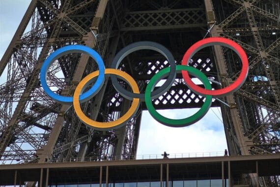 Eiffelturm mit Olympischen Ringen symbolisiert Sportfreiheit, während Hamburg sich gegen Spiele entscheidet.