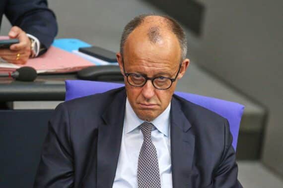 Friedrich Merz bei einer politischen Veranstaltung, umgeben von Medienvertretern und politischen Unterstützern.