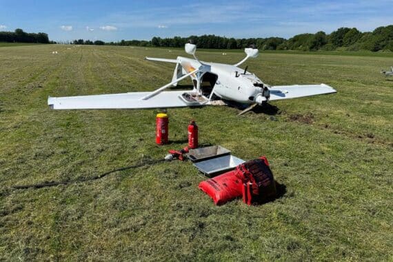 Kleinflugzeug liegt auf dem Dach, Feuerwehr sichert Unfallstelle, Rettungskräfte im Einsatz.