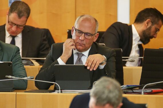 Ein berätender Innenminister Poseck in einem modernen Büro, Symbol für Hass- und Hetze-Bekämpfung.