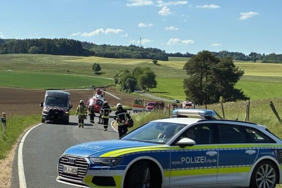 Verkehrsunfall auf Kreisstraße, Rettungskräfte vor Ort, beschädigte Fahrzeuge, gesperrte Fahrbahn.